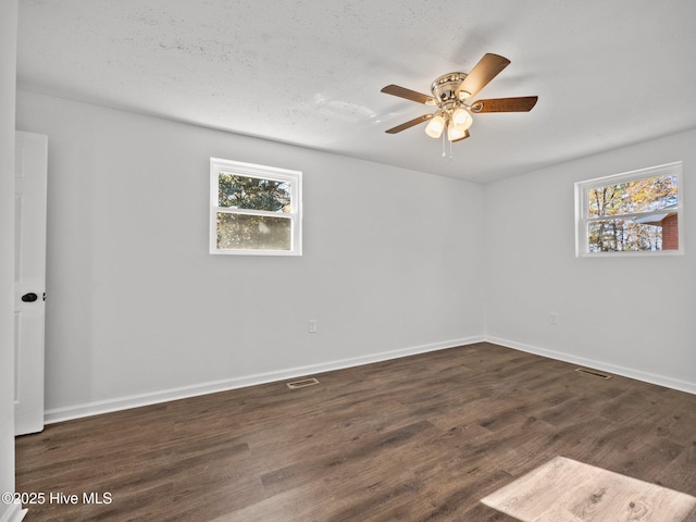 empty room featuring a textured ceiling, ceiling fan, and dark hardwood / wood-style floors