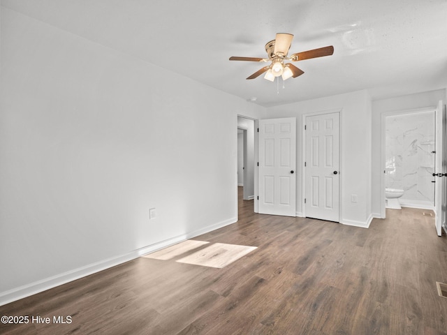 unfurnished bedroom featuring connected bathroom, ceiling fan, and dark hardwood / wood-style floors