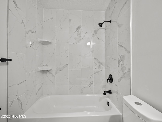 bathroom with toilet, tiled shower / bath combo, and a textured ceiling