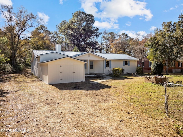 view of front of home featuring a shed and a front lawn