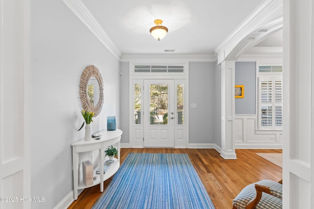 entryway with ornamental molding, decorative columns, and hardwood / wood-style floors