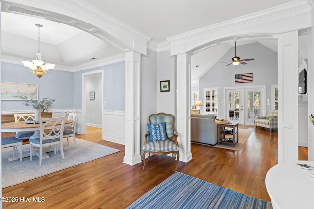 foyer entrance with ceiling fan with notable chandelier, decorative columns, lofted ceiling, dark hardwood / wood-style flooring, and french doors