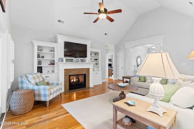 living room with ceiling fan, high vaulted ceiling, and light wood-type flooring