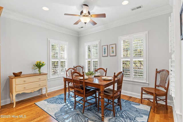 dining room with hardwood / wood-style flooring, ornamental molding, and ceiling fan