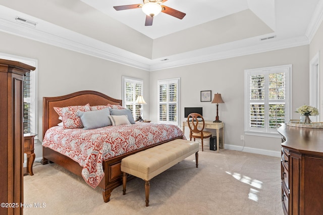 carpeted bedroom with multiple windows, a tray ceiling, and ornamental molding