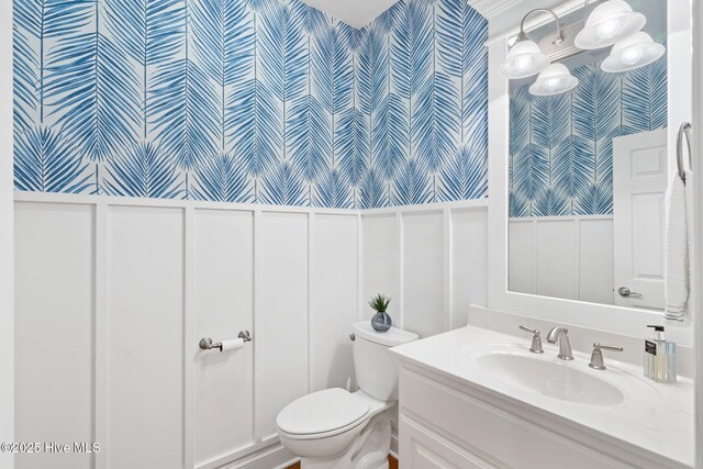 552 Glenmora Ave SW, Supply, NC 28462 - bathroom featuring wallpapered walls, a decorative wall, toilet, a wainscoted wall, and vanity