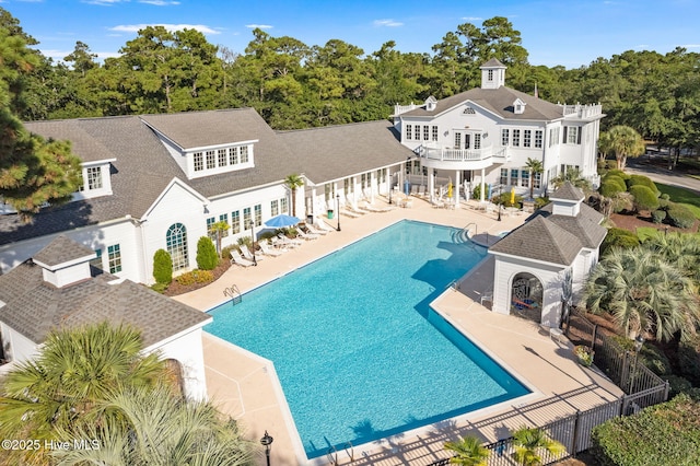 back of property with a balcony, a fenced in pool, and a patio area