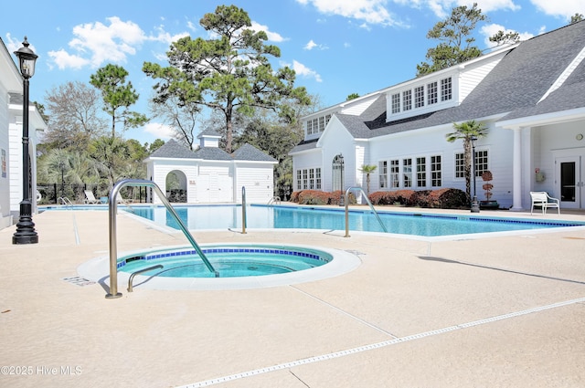 view of swimming pool with a hot tub and a patio