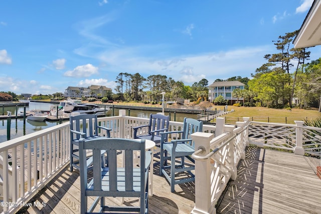 wooden deck featuring a water view and a lawn