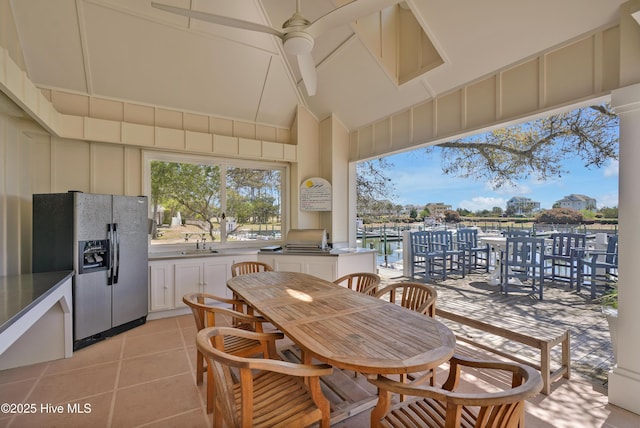 view of patio with a water view and ceiling fan