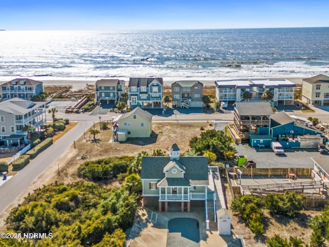 birds eye view of property with a water view and a view of the beach