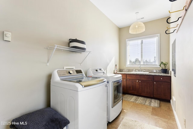 laundry area with sink, separate washer and dryer, and cabinets