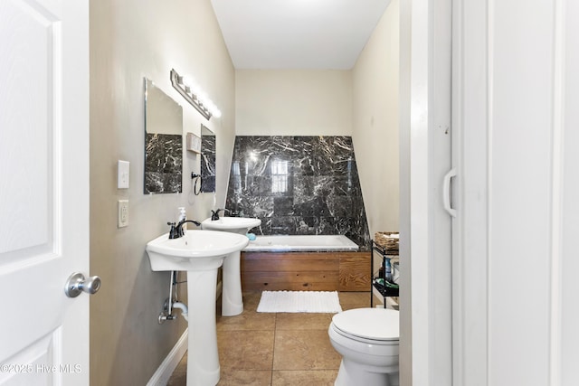 bathroom with a tub, sink, tile patterned floors, and toilet