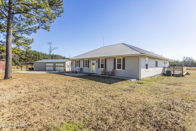 ranch-style house with a front yard, a carport, central AC unit, a garage, and an outdoor structure