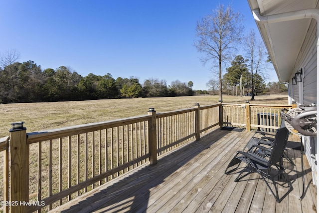 wooden deck featuring a rural view and a yard