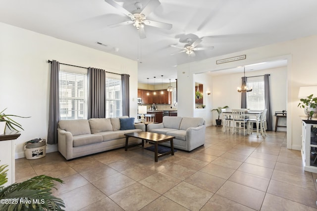 tiled living room with ceiling fan with notable chandelier and sink