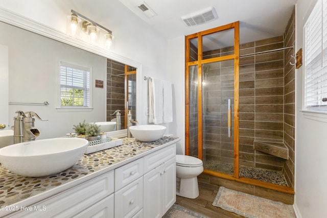 bathroom with toilet, hardwood / wood-style flooring, an enclosed shower, and vanity