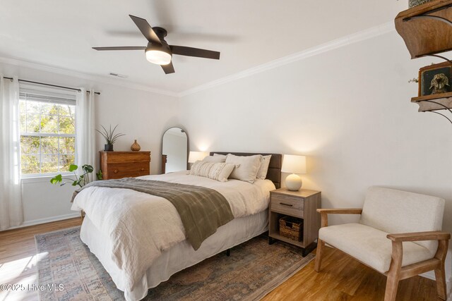 bedroom featuring ceiling fan, light hardwood / wood-style flooring, and crown molding