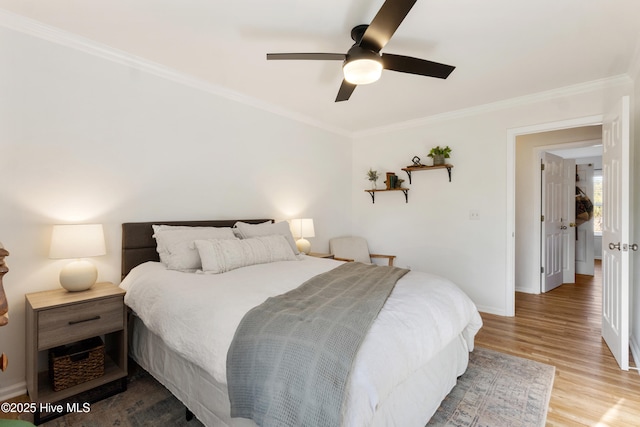 bedroom featuring ceiling fan, crown molding, and hardwood / wood-style flooring