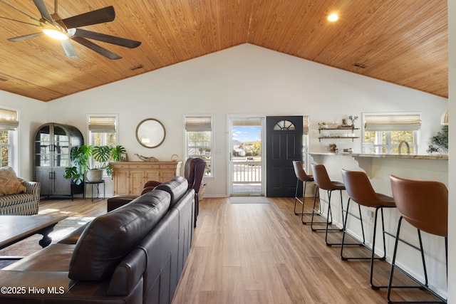 living room with wood ceiling, light wood-type flooring, ceiling fan, high vaulted ceiling, and sink