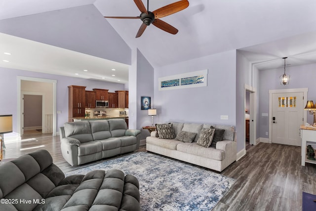 living room featuring high vaulted ceiling, dark hardwood / wood-style floors, and ceiling fan with notable chandelier