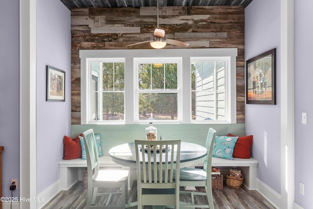 dining space featuring hardwood / wood-style flooring and wooden walls