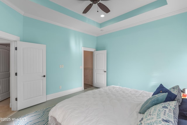 bedroom with ceiling fan, ornamental molding, and a tray ceiling