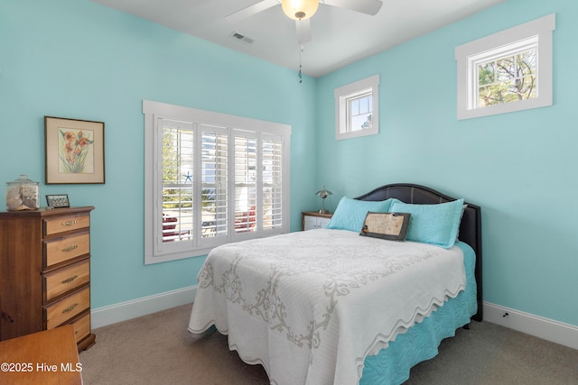 bedroom featuring ceiling fan, light colored carpet, and multiple windows