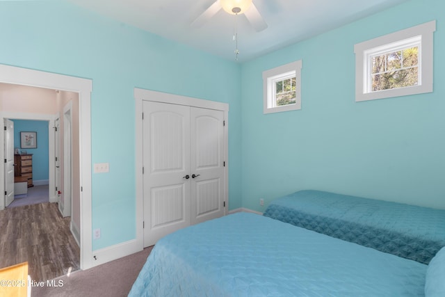 carpeted bedroom with ceiling fan and a closet