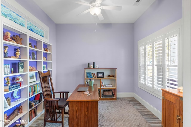 carpeted home office with ceiling fan