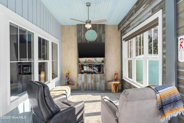 living room featuring ceiling fan, wood ceiling, and wood walls