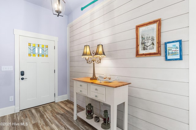 foyer entrance featuring dark wood-type flooring and wood walls