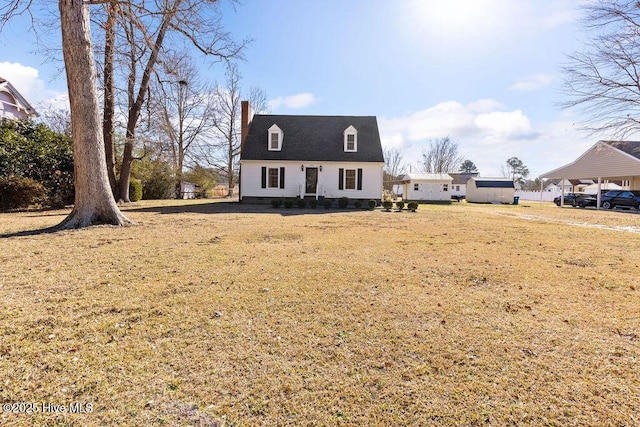 cape cod house featuring a front yard and a carport