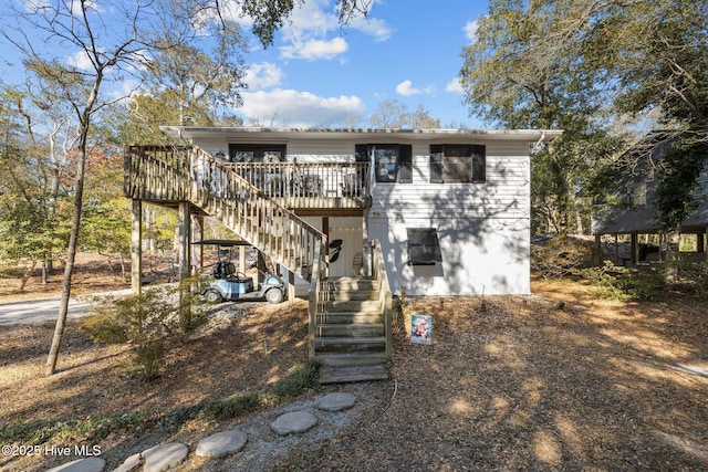 rear view of house featuring a wooden deck