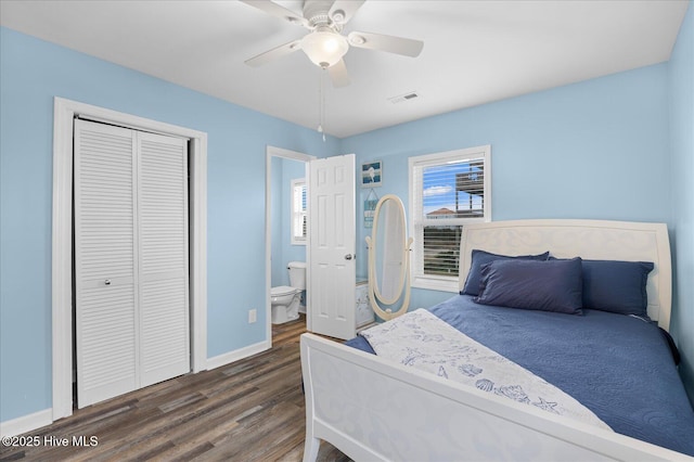 bedroom with ceiling fan, ensuite bath, dark wood-type flooring, and a closet