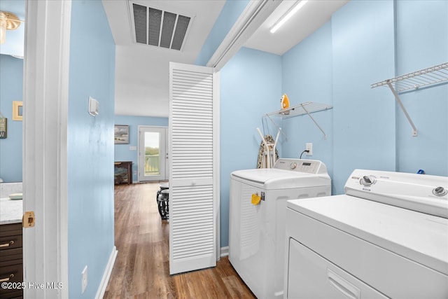 washroom with dark hardwood / wood-style flooring and independent washer and dryer