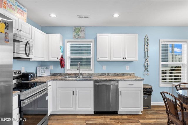 kitchen featuring white cabinets, dark hardwood / wood-style flooring, sink, and appliances with stainless steel finishes