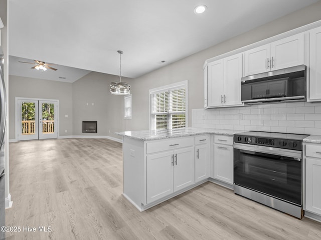kitchen with stainless steel microwave, light wood-style floors, electric range, and a peninsula
