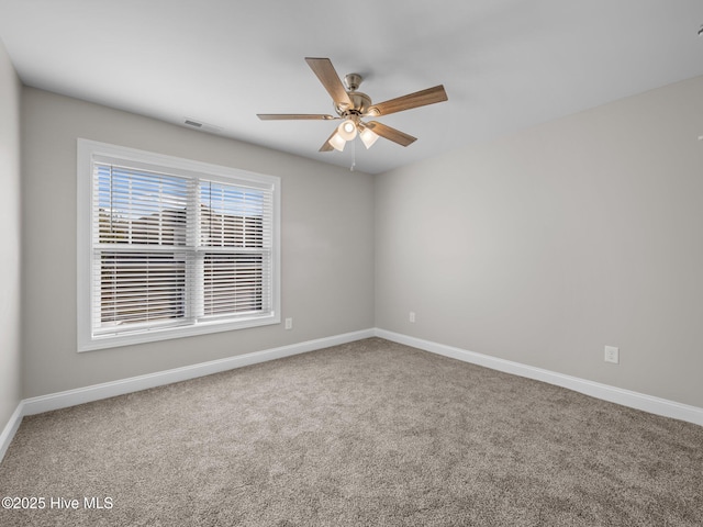 empty room with ceiling fan, carpet floors, and baseboards