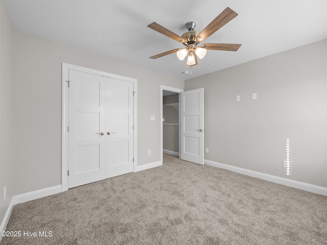 unfurnished bedroom featuring carpet floors, a closet, baseboards, and ceiling fan