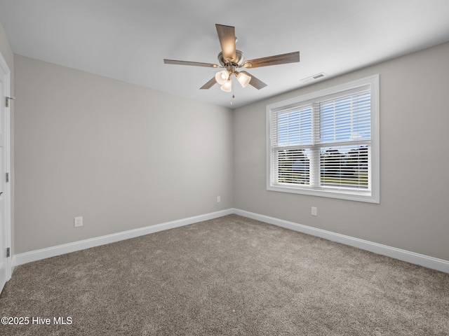 spare room featuring baseboards, visible vents, carpet floors, and ceiling fan
