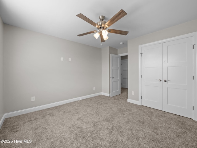 unfurnished bedroom with a closet, carpet flooring, baseboards, and a ceiling fan