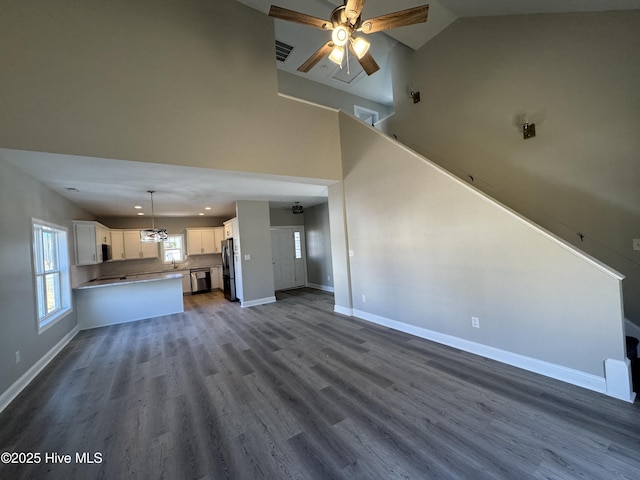 unfurnished living room with high vaulted ceiling, dark wood-type flooring, a ceiling fan, recessed lighting, and baseboards