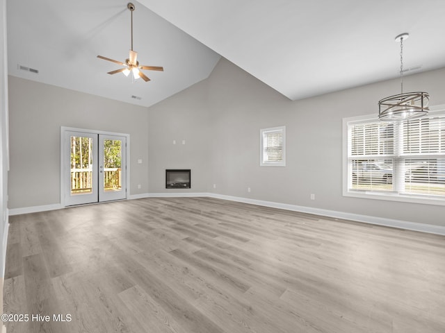 unfurnished living room featuring high vaulted ceiling, baseboards, and visible vents