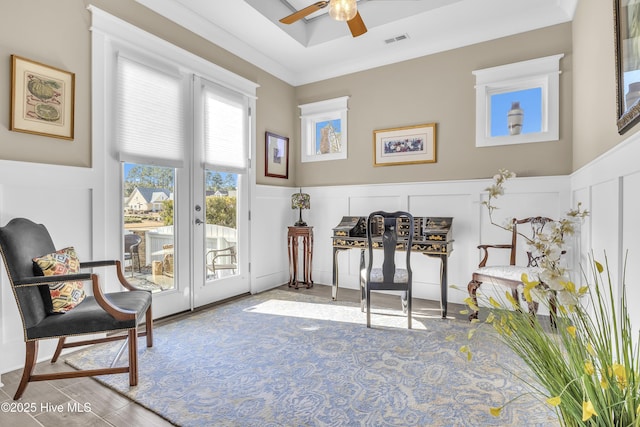 living area with ceiling fan and crown molding