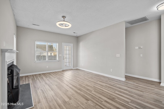 2214 Splitbrook Ct, Wilmington, NC 28411 - unfurnished living room with wood finished floors, a textured ceiling, baseboards, and a fireplace