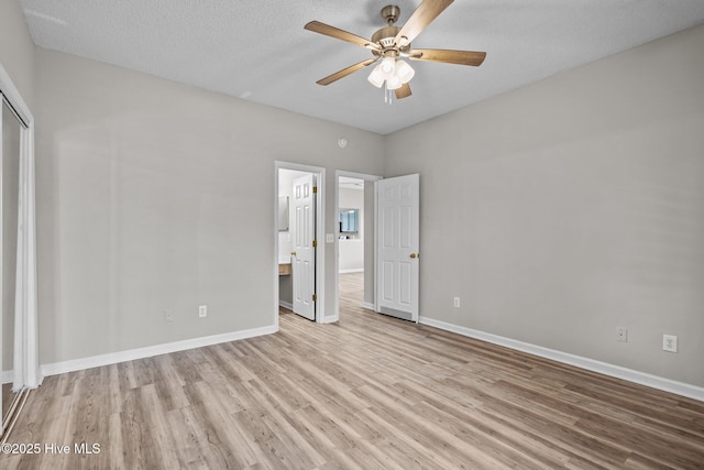 2214 Splitbrook Ct, Wilmington, NC 28411 - unfurnished bedroom featuring wood finished floors, baseboards, ensuite bath, a closet, and a textured ceiling