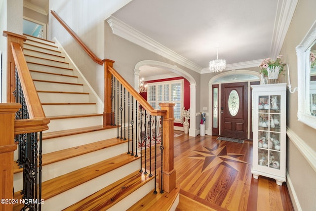 entrance foyer with crown molding, dark hardwood / wood-style floors, and an inviting chandelier