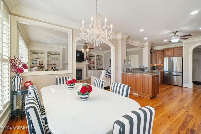 dining space with crown molding, ceiling fan, and light wood-type flooring