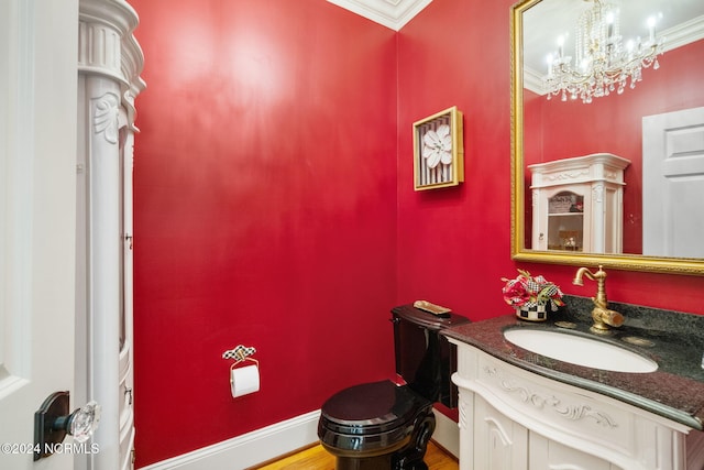 bathroom with toilet, crown molding, vanity, a notable chandelier, and hardwood / wood-style flooring